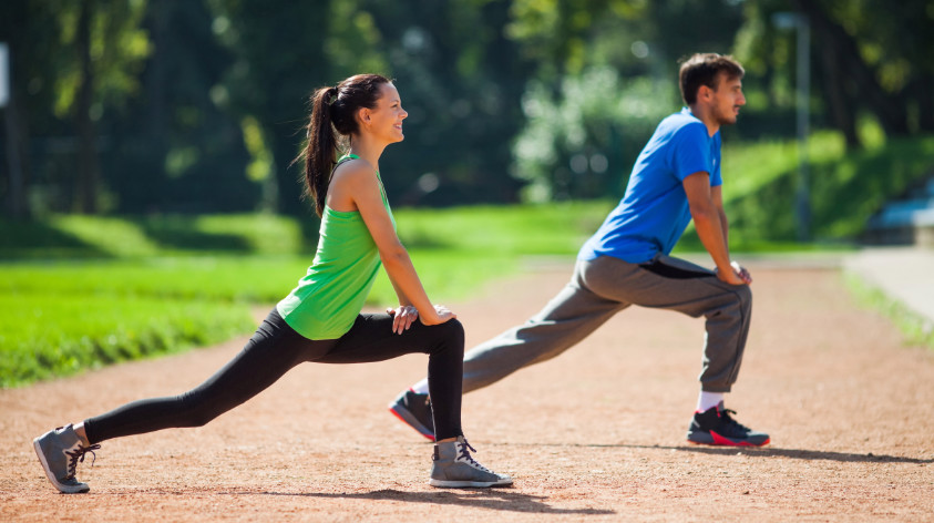 Nach dem Joggen dehnen - Paar macht Dehnübungen nach dem Joggen