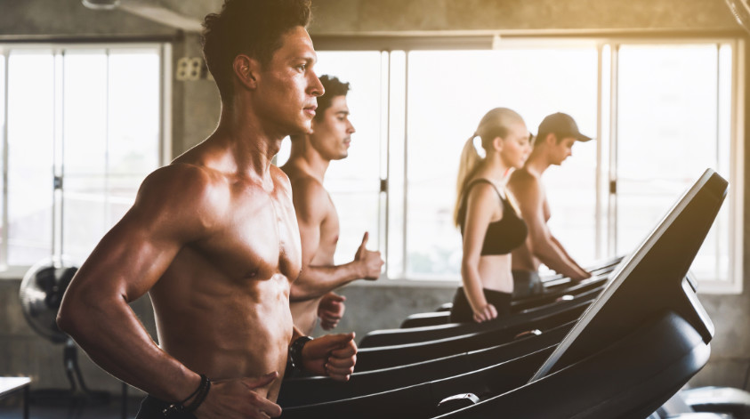 Gruppe junger Menschen macht HIIT Laufband Training